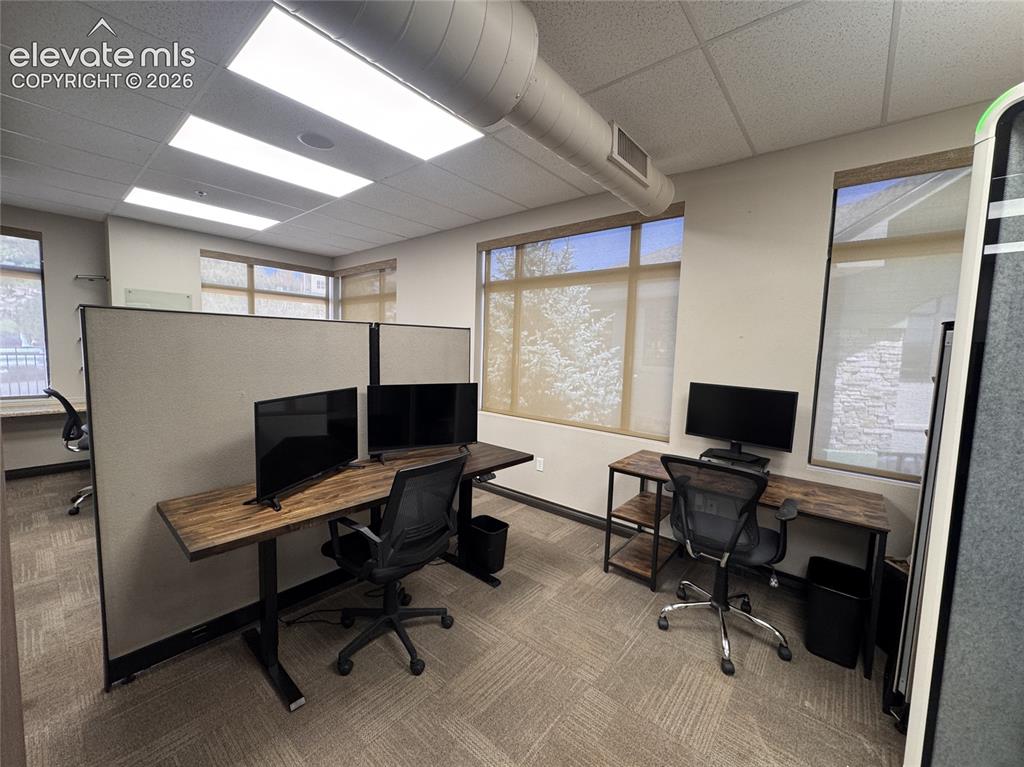 Image 8 of 17: Recessed ceiling lighting, exposed ductwork, multiple windows with roller s