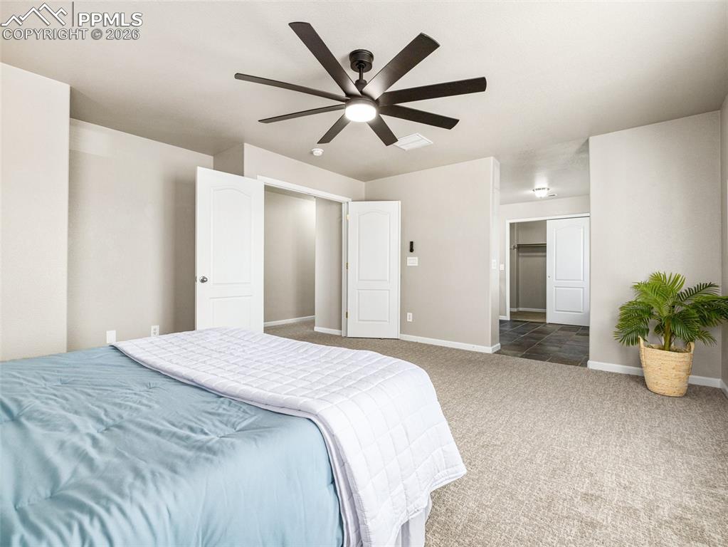 Image 17 of 23: Bedroom with ceiling fan and carpet