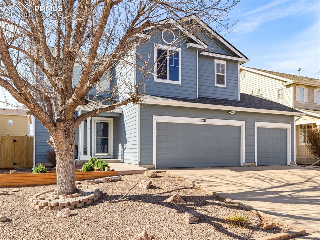 Image 2 of 23: Traditional home with driveway, a garage, and roof with shingles