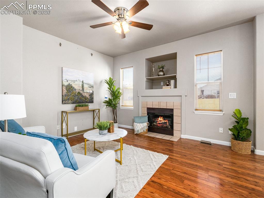 Image 3 of 23: Living room with a ceiling fan, hardwood / wood-style flooring, and a firep
