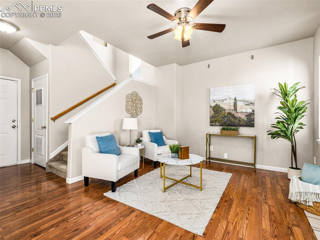 Image 4 of 23: Living area with dark wood-style floors and ceiling fan