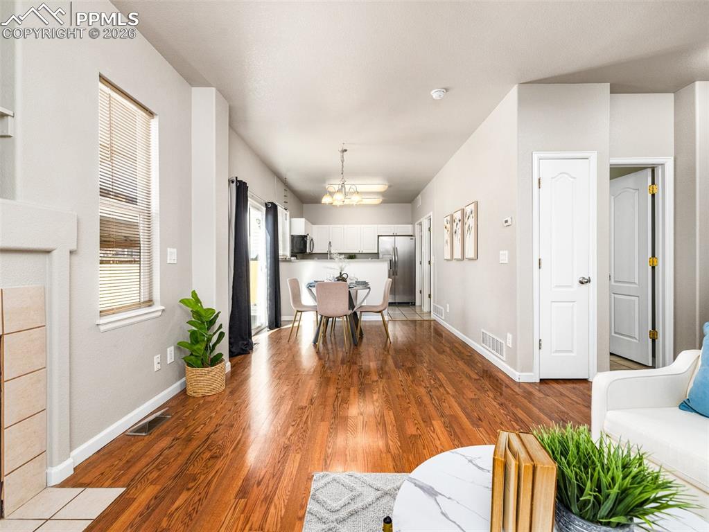 Image 5 of 23: Living room featuring wood finished floors and a chandelier