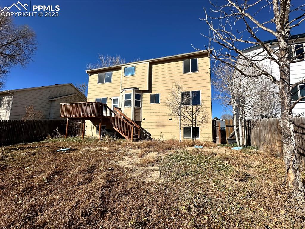 Image 16 of 16: Rear view of property featuring stairway and a wooden deck