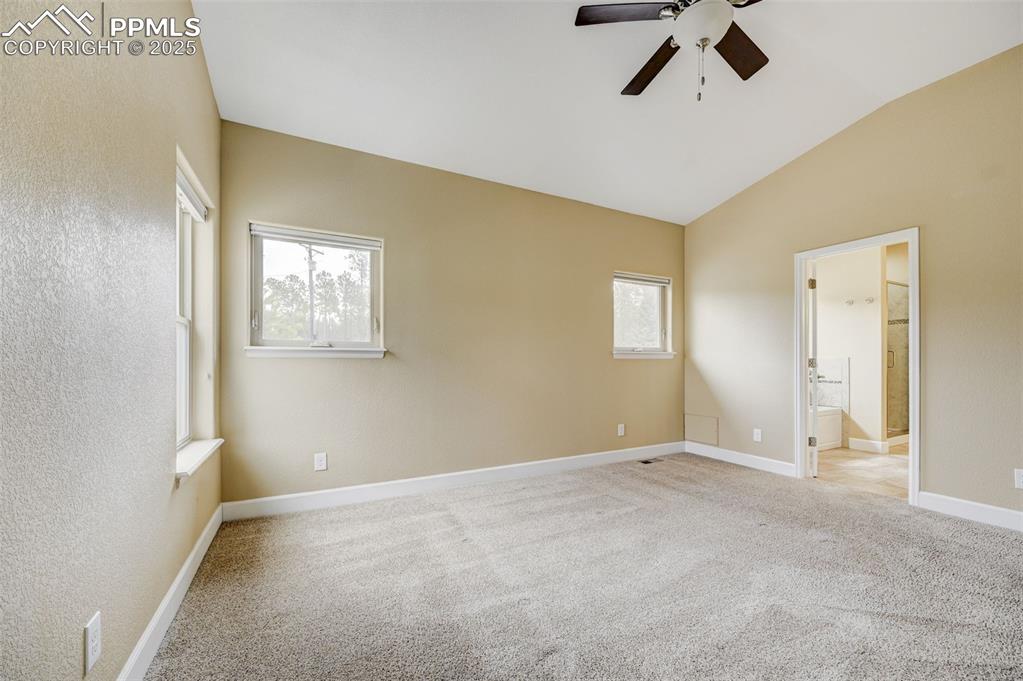 Image 13 of 30: Unfurnished bedroom featuring baseboards, light carpet, and lofted ceiling