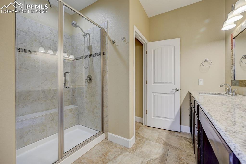 Image 16 of 30: Full bath with vanity, baseboards, and a stall shower