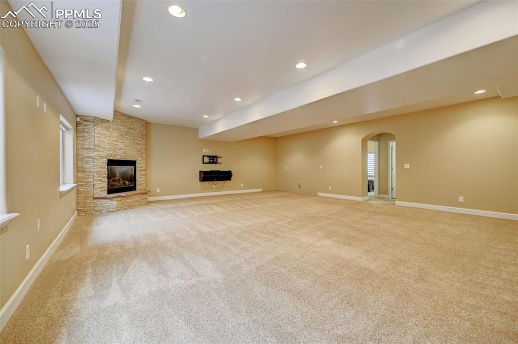 Image 24 of 30: Unfurnished living room featuring recessed lighting, baseboards, a fireplac