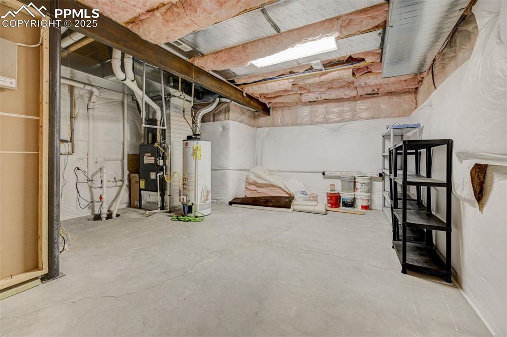 Image 28 of 30: Unfinished basement with gas water heater