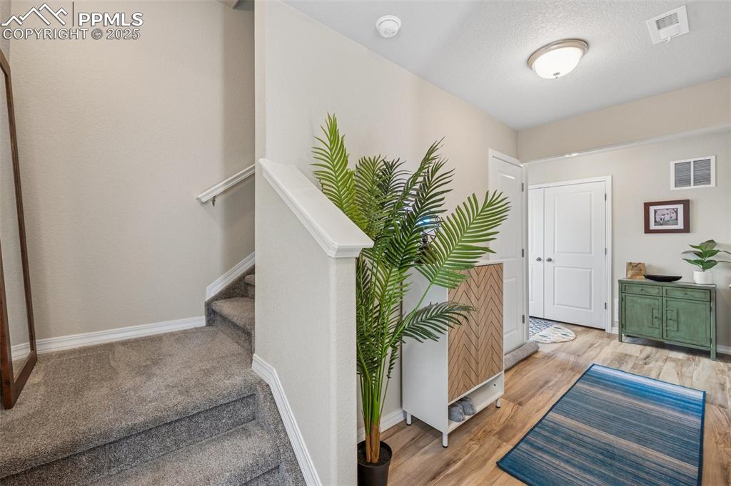 Image 11 of 29: Entryway with light wood-style floors, baseboards, and stairs