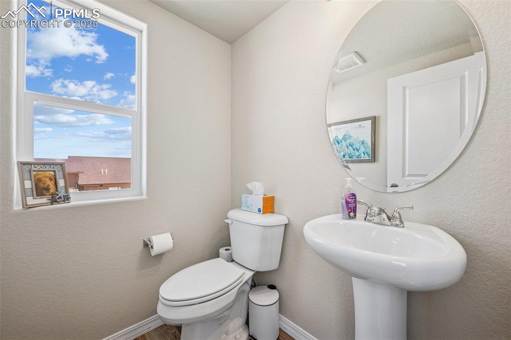 Image 12 of 29: Half bathroom featuring toilet, baseboards, and wood finished floors