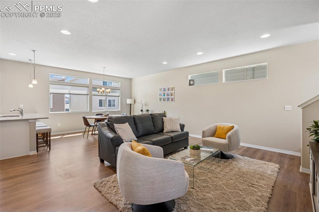 Image 13 of 29: Living area featuring wood finished floors, recessed lighting, baseboards, 