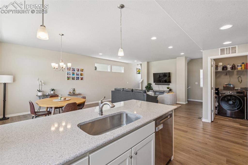 Image 20 of 29: Kitchen with a sink, stainless steel dishwasher, wood finished floors, inde