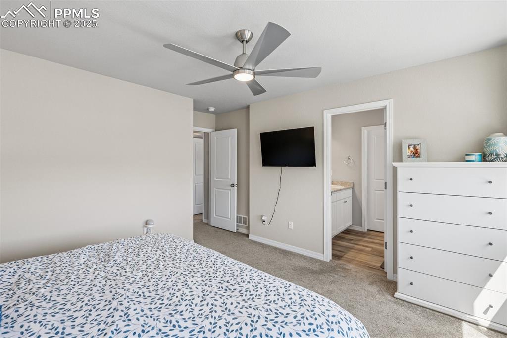 Image 28 of 29: Bedroom featuring light carpet, baseboards, ensuite bathroom, and a ceiling