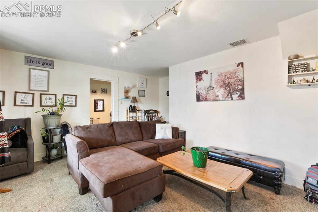 Image 34 of 49: Carpeted living area featuring visible vents and track lighting