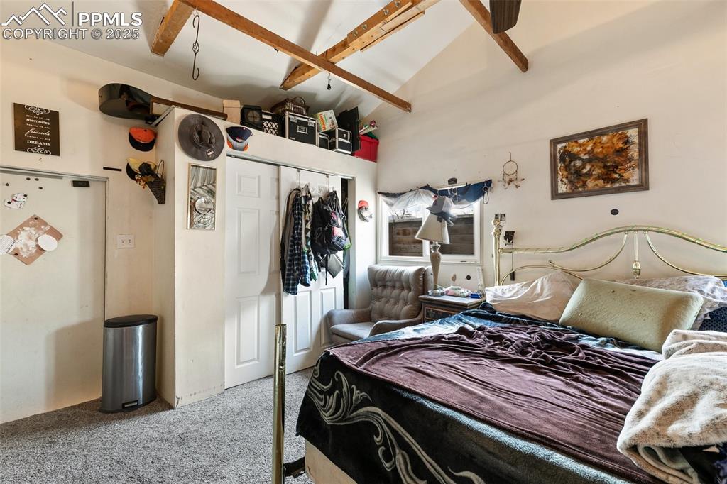 Image 38 of 49: Carpeted bedroom featuring lofted ceiling with beams and a closet