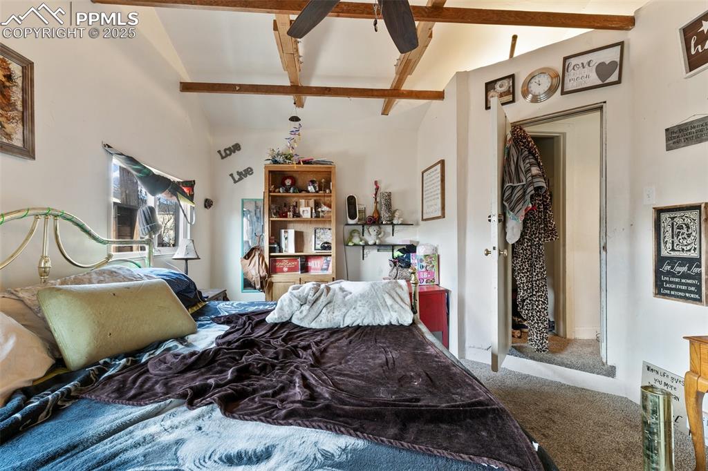 Image 39 of 49: Carpeted bedroom with beam ceiling and a ceiling fan