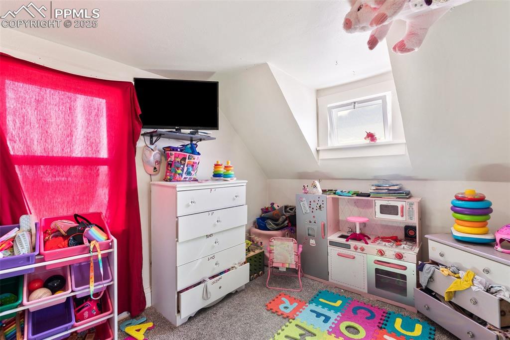 Image 46 of 49: Playroom featuring carpet and vaulted ceiling