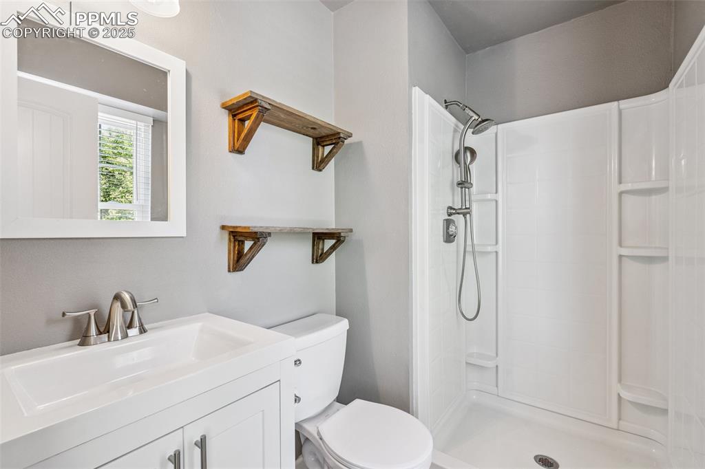 Image 12 of 22: Bathroom with a tile shower and vanity
