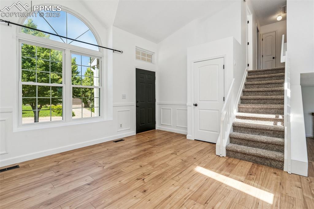 Image 5 of 22: Entryway featuring stairway, light wood finished floors, high vaulted ceili