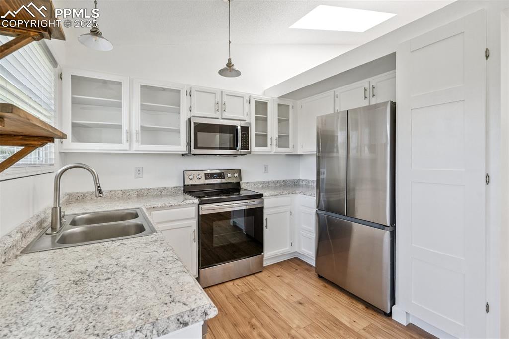 Image 7 of 22: Kitchen featuring stainless steel appliances, light wood-style flooring, an