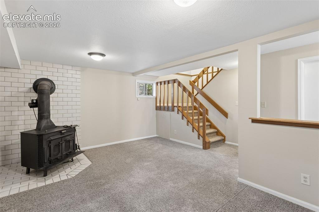 Image 26 of 40: Wood burning fireplace in basement
