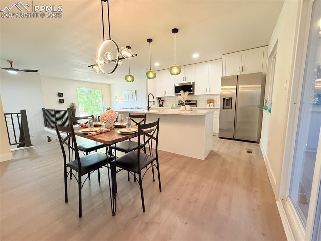Image 20 of 50: Dining space with light wood-style floors, recessed lighting, and a ceiling