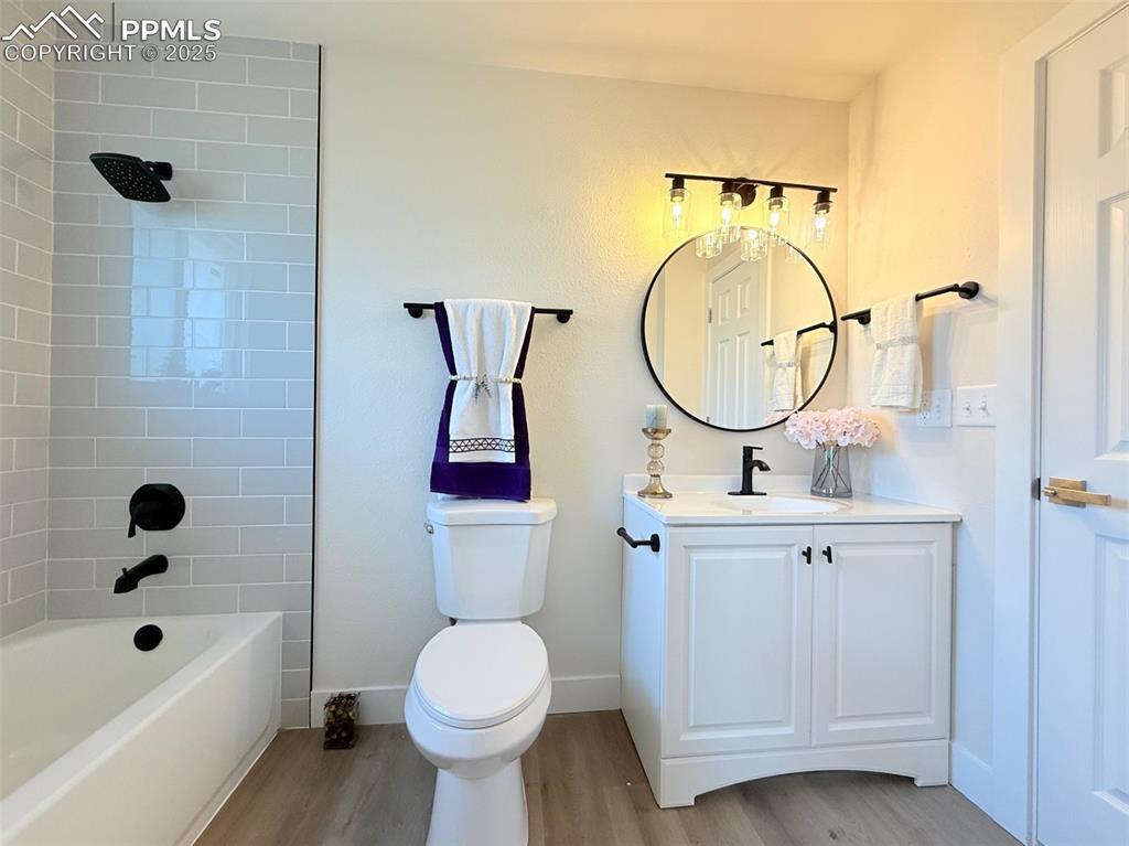 Image 26 of 50: Full bathroom with light wood-style flooring, shower / bath combination, an