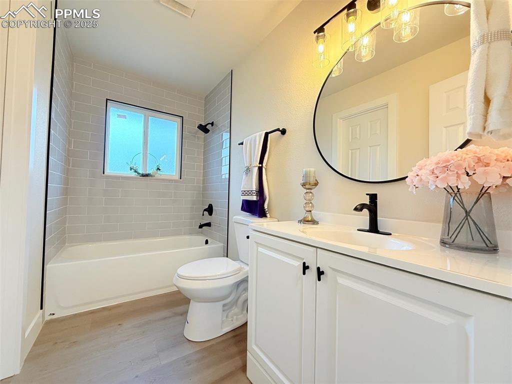 Image 27 of 50: Bathroom with shower / washtub combination, vanity, and light wood finished