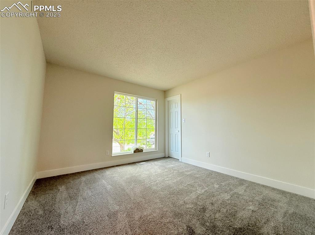 Image 28 of 50: Carpeted spare room featuring a textured ceiling and baseboards