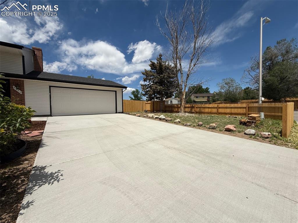 Image 4 of 50: Garage with concrete driveway