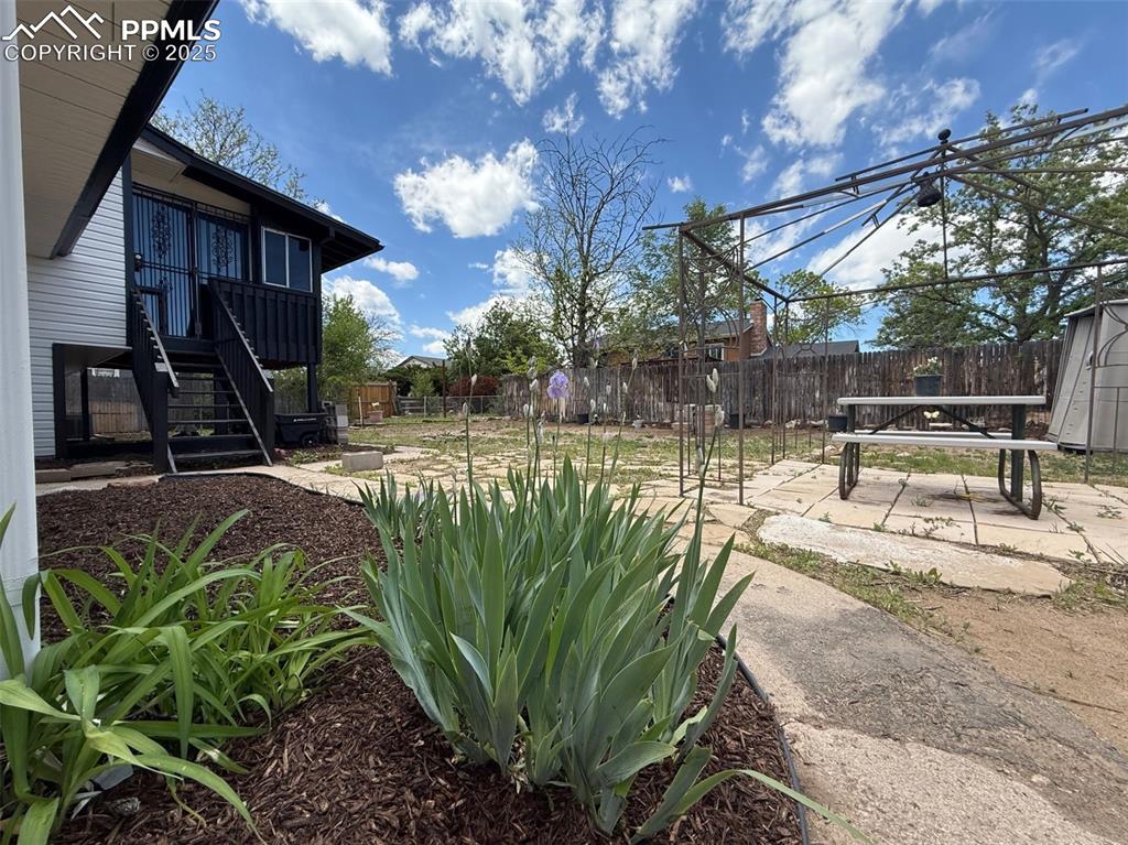 Image 48 of 50: Fenced backyard featuring a patio, stairway, and a shed