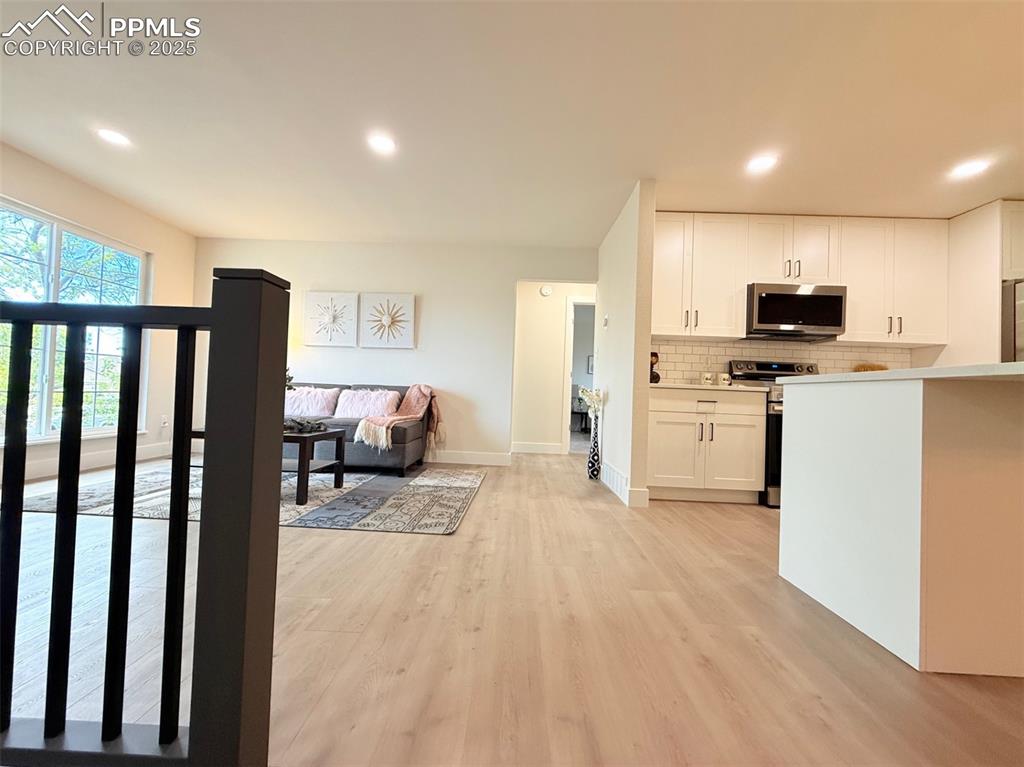Image 7 of 50: Kitchen with tasteful backsplash, appliances with stainless steel finishes,