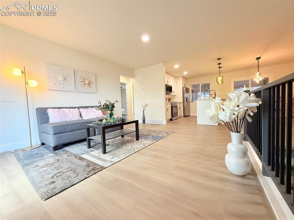 Image 8 of 50: Living area featuring light wood-style floors and recessed lighting