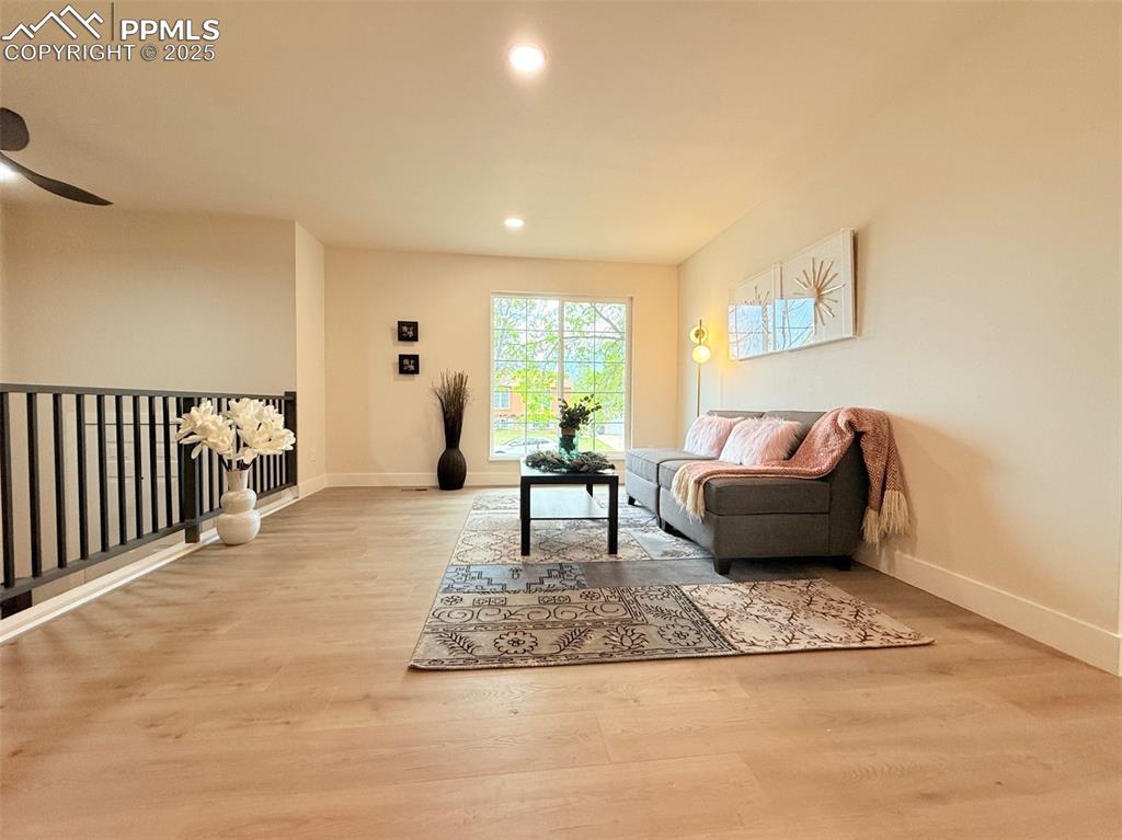 Image 9 of 50: Living room with light wood-style floors, recessed lighting, and ceiling fa