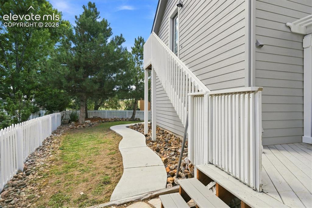 Image 44 of 50: Fully fenced yard with mature landscaping