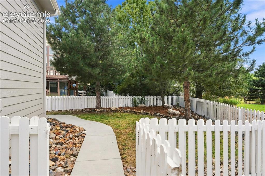 Image 45 of 50: Fully fenced yard with mature landscaping