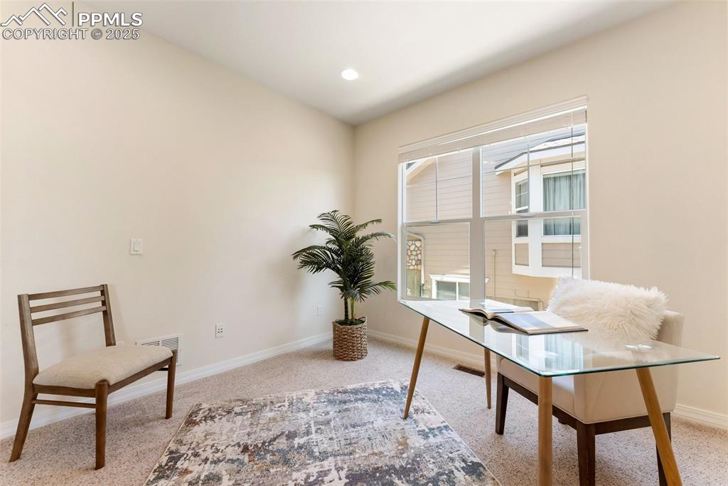 Image 16 of 48: Home office with baseboards and light carpet