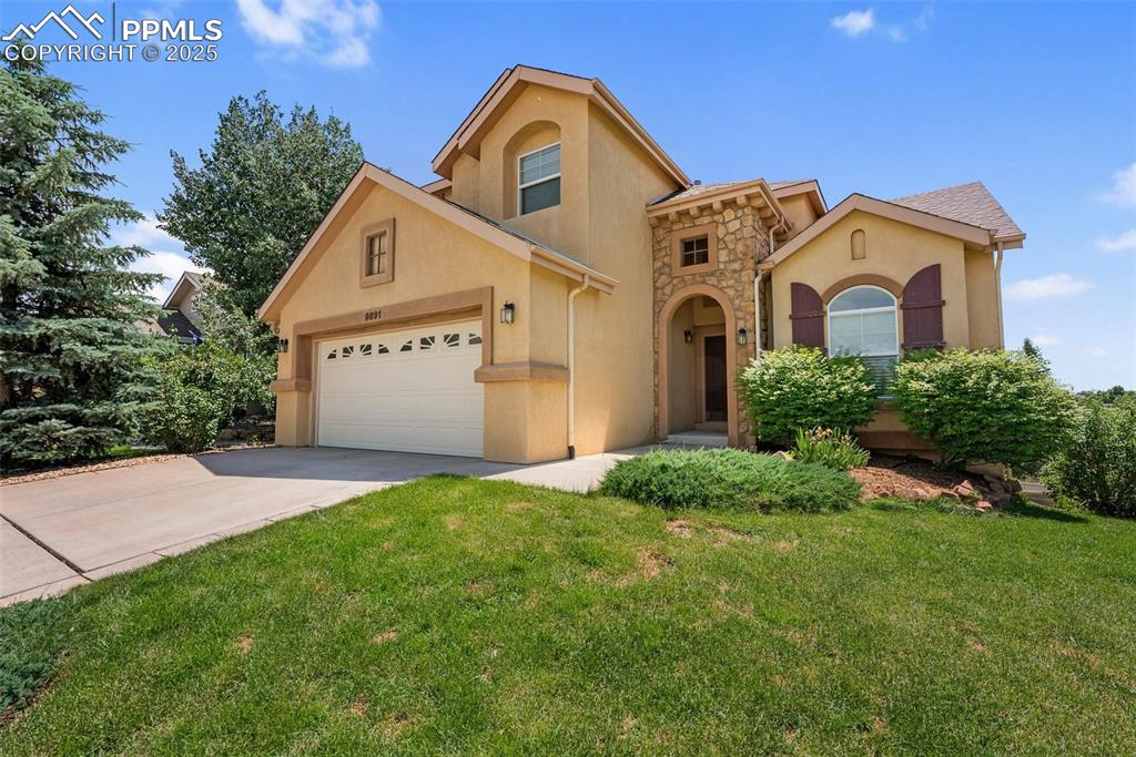 Image 2 of 48: Mediterranean / spanish-style home with stucco siding, a garage, and a fron