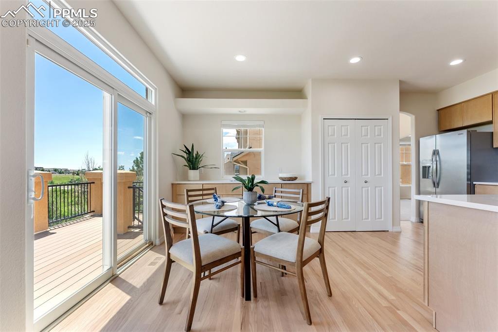 Image 20 of 48: Dining room with light wood-type flooring and recessed lighting