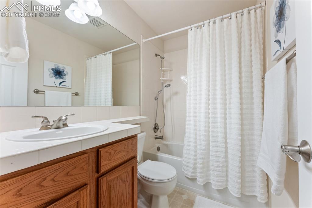 Image 24 of 48: Full bathroom featuring shower / bathtub combination with curtain, vanity,