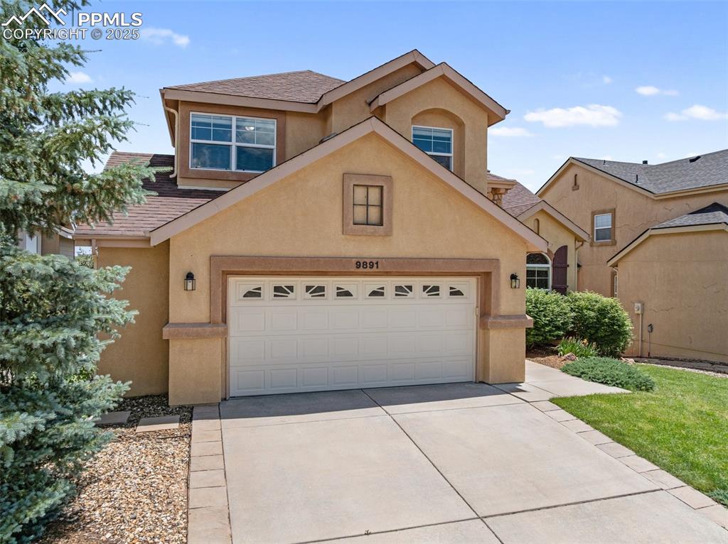 Image 3 of 48: Traditional-style home with stucco siding, concrete driveway, and a garage