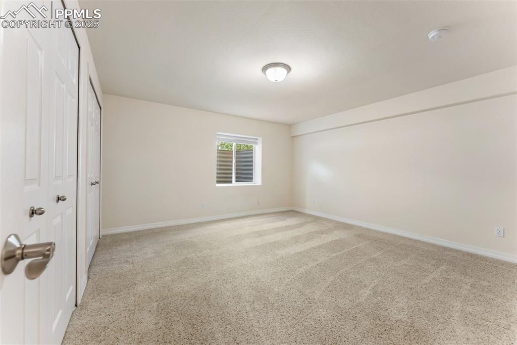 Image 38 of 48: Unfurnished bedroom with baseboards and light carpet