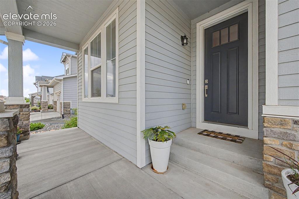 Image 2 of 45: The covered front porch welcomes all & provides a place to sit and relax.