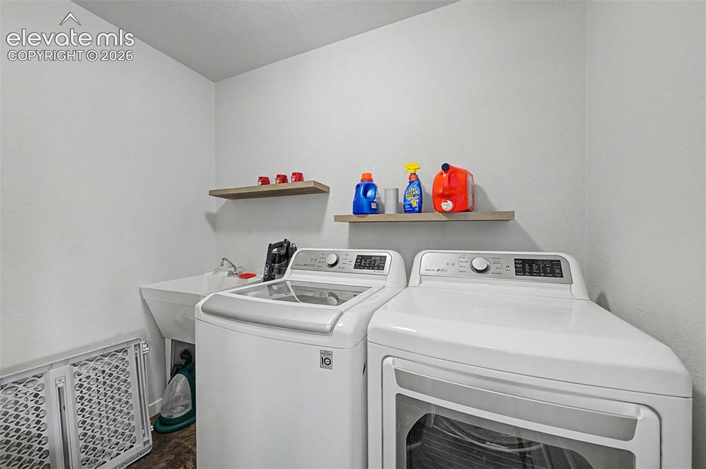 Image 21 of 45: The convenient upper level laundry room includes a utility sink. Washer/dry