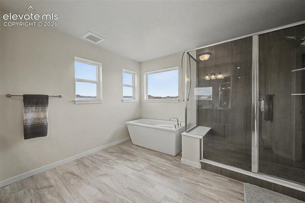 Image 25 of 45: Wow! The roomy primary bath features a soaking tub and oversized, glass enc