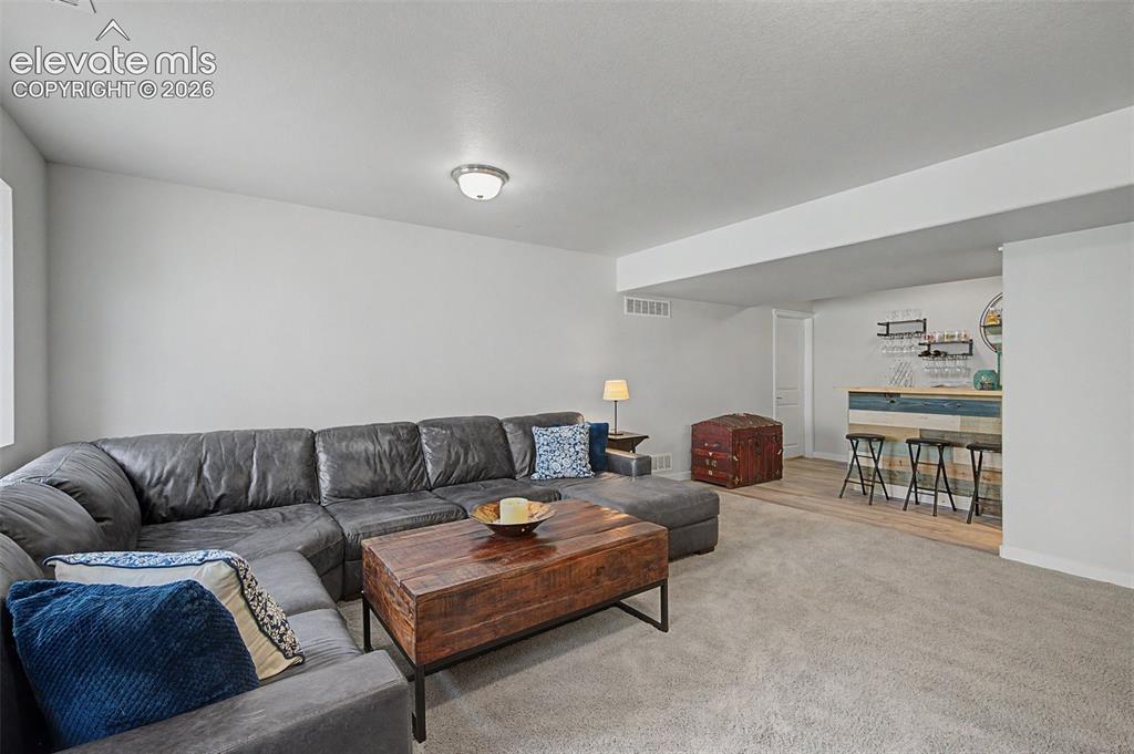 Image 37 of 45: Basement family room offers a convenient wet bar to make entertaining a bre