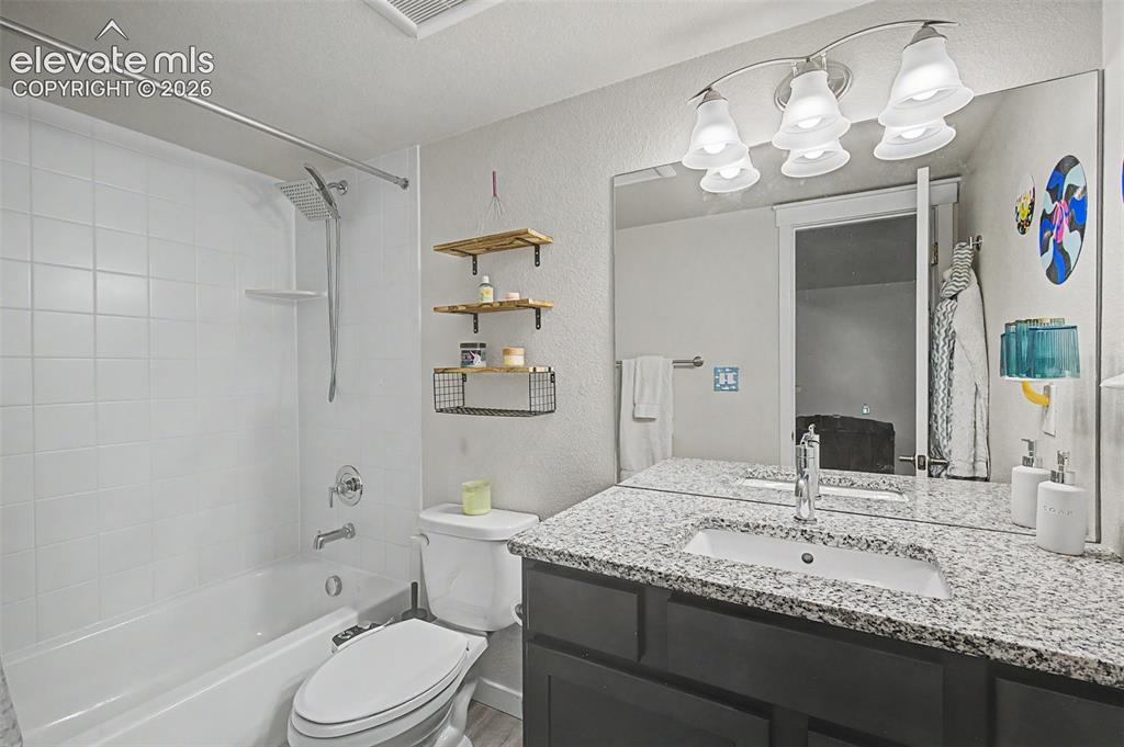 Image 38 of 45: Basement full bath features a granite topped vanity.