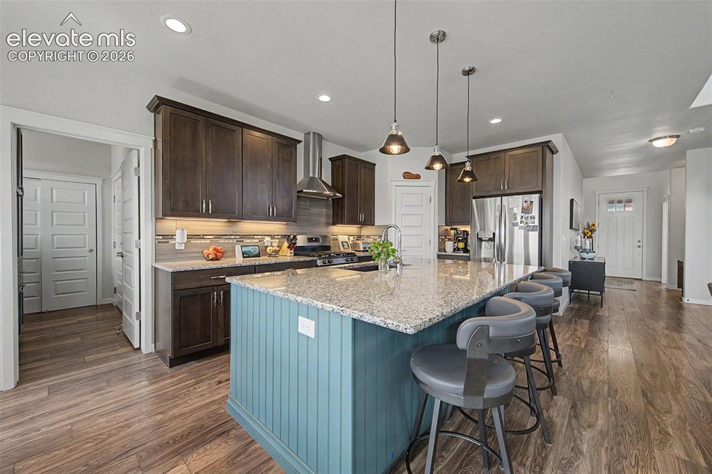 Image 9 of 45: The inviting kitchen boasts a custom tile backsplash and informal seating a
