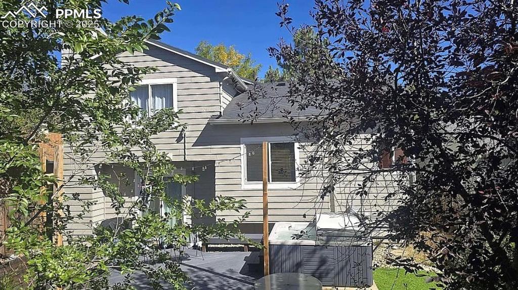 Image 29 of 41: View of side of home with a patio area and a shingled roof