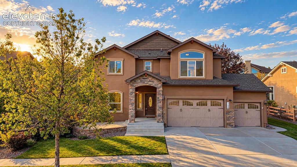 Image 1 of 49: Stucco exterior with stone accents, arched entry, multiple garage doors, fr