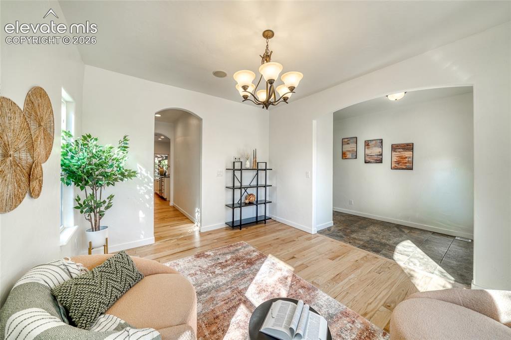 Image 11 of 49: Archways define separate spaces with wood-finish flooring and a multi-light